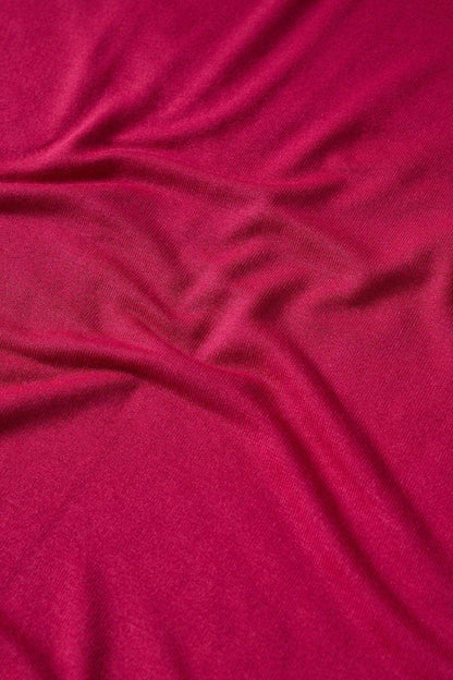 Close-up of strawberry magenta knit fabric for turtleneck top