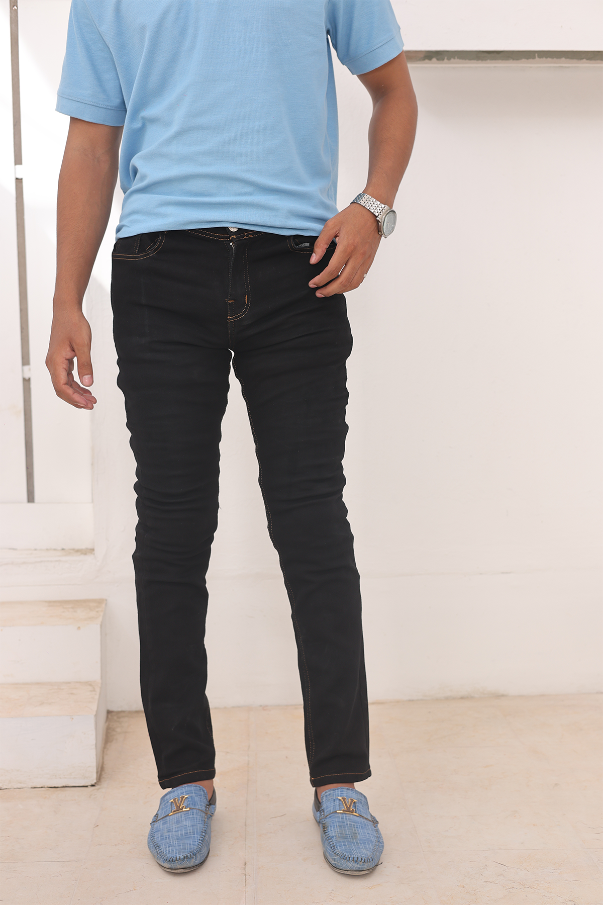 Jet black slim-fit jeans with contrast orange-stitched seams and belt loops