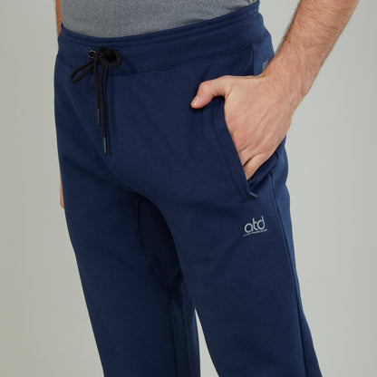 Men's navy jogger pants close-up: drawstring waist, side pockets, atd logo