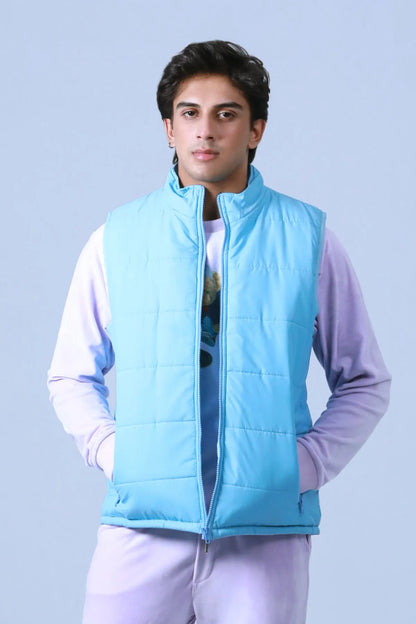 Blue quilted puffer vest with hood and zip front over a hoodie