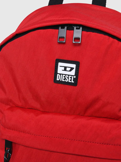 Red backpack front with Diesel logo patch and two top metal buckles