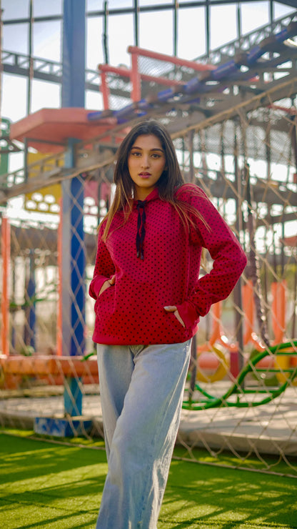 Red polka-dot hoodie with bow tie, worn with light blue wide-leg jeans
