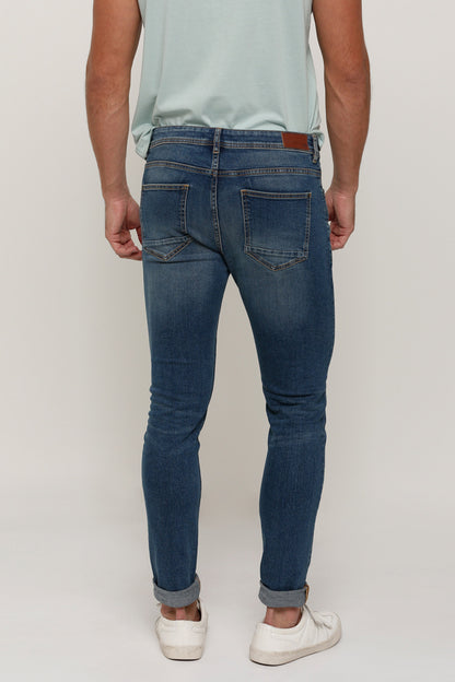 Blue denim jeans with belt loops, back yoke seam, and five-pocket styling