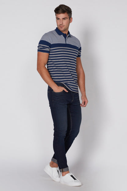 Men's blue striped polo shirt, walking view with dark jeans and white sneakers