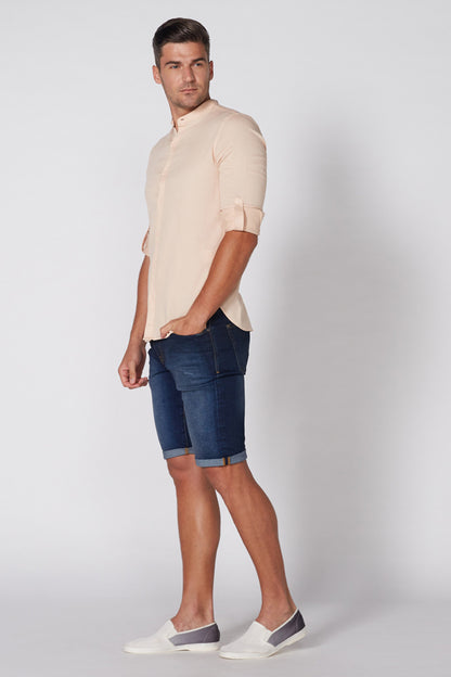 Men's blue denim shorts with cuffed knee length, worn with white sneakers