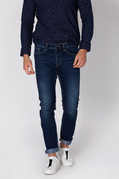 Men's blue dotted button-up shirt and dark blue denim jeans with cuffed hems
