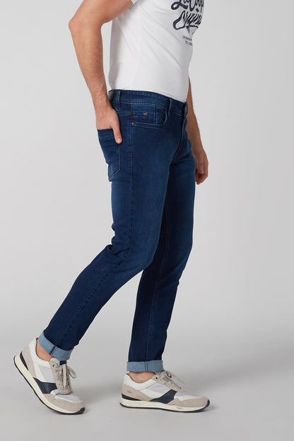 Blue denim jeans close-up of front pocket and tapered leg hem