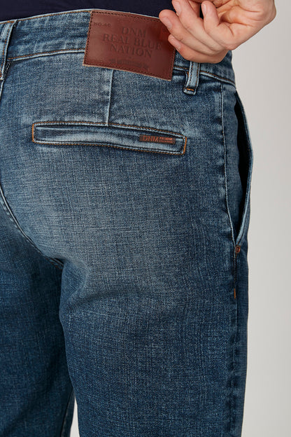 Blue denim jeans close-up with leather brand patch, front pocket and coin pocket