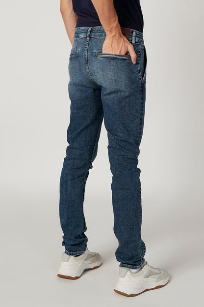Blue denim jeans, side view, mid-rise with belt loops and stitched pockets