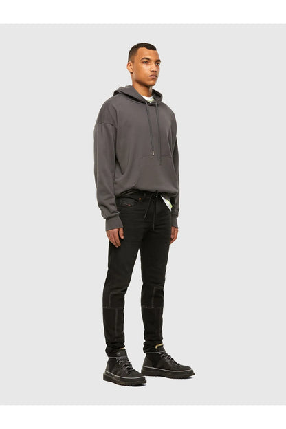 Diesel charcoal jeans worn with a hoodie and sneakers, full-body side view