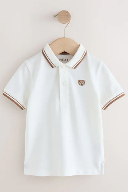Children's white polo shirt front view with brown-striped collar and teddy bear patch