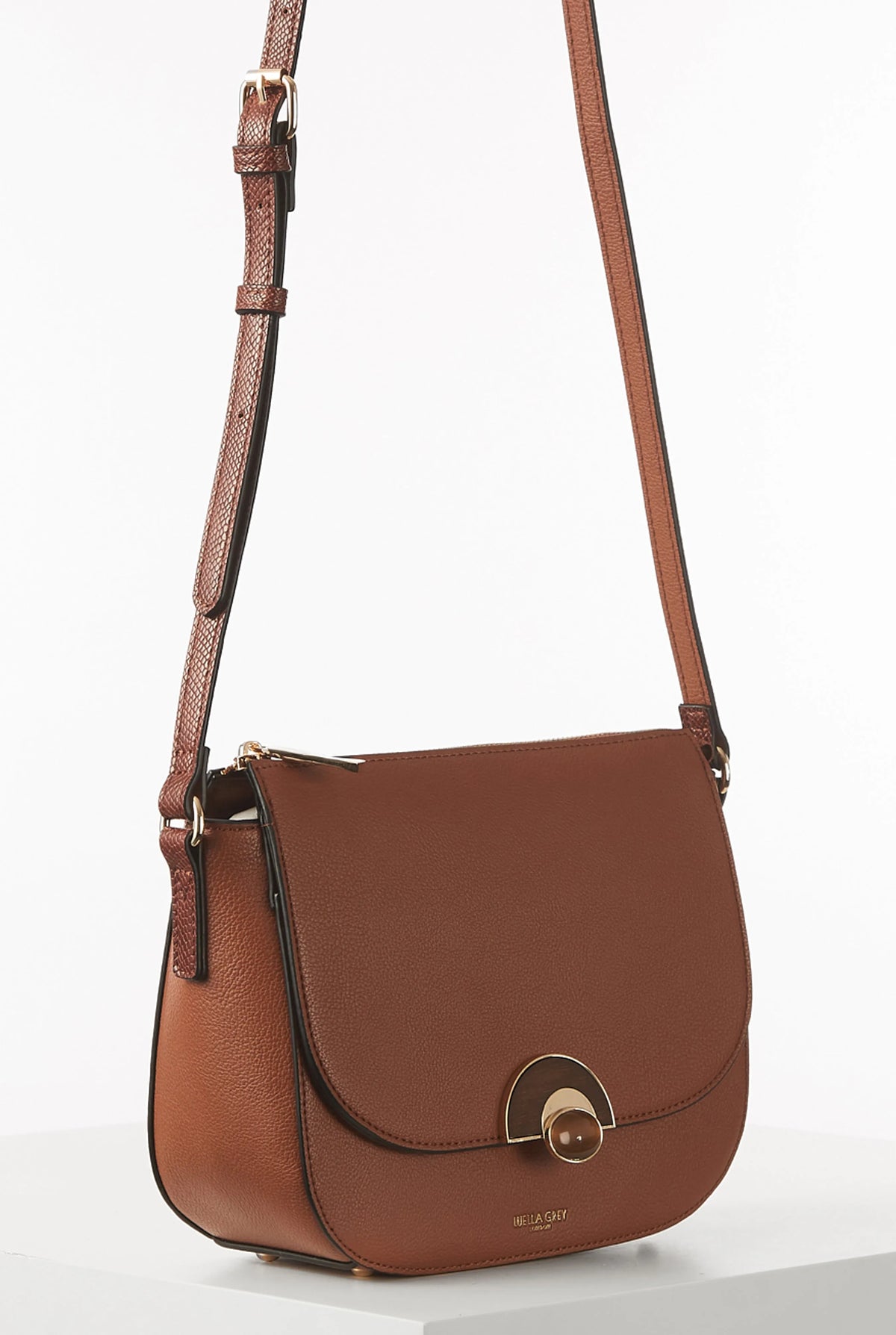 Brown crossbody bag with flap closure and adjustable shoulder strap