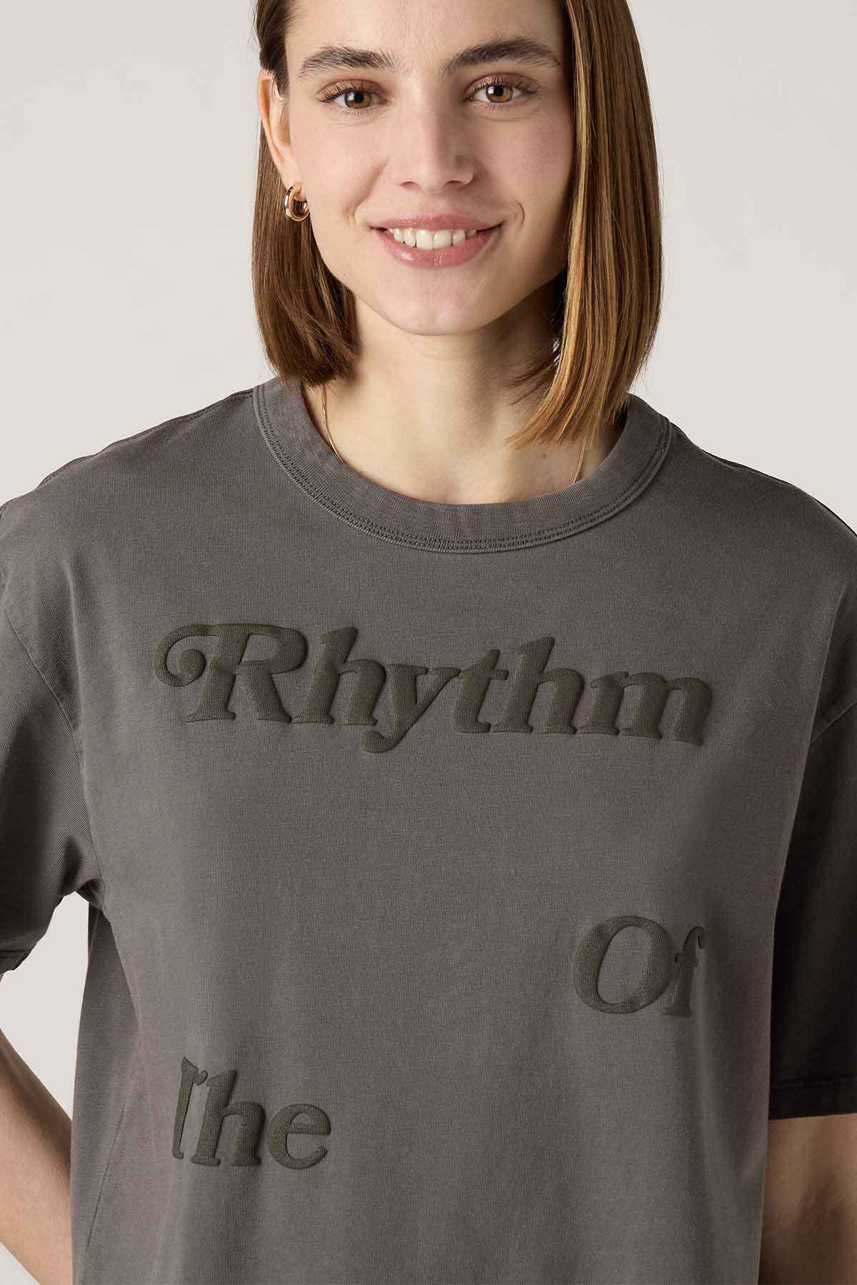 Women's dark gray T-shirt close-up with 'Rhythm' and 'Or' text