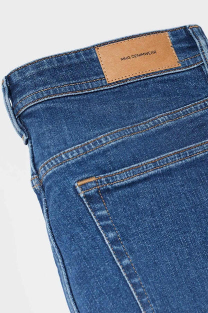 Blue denim jeans waistband detail with leather patch and stitched pockets