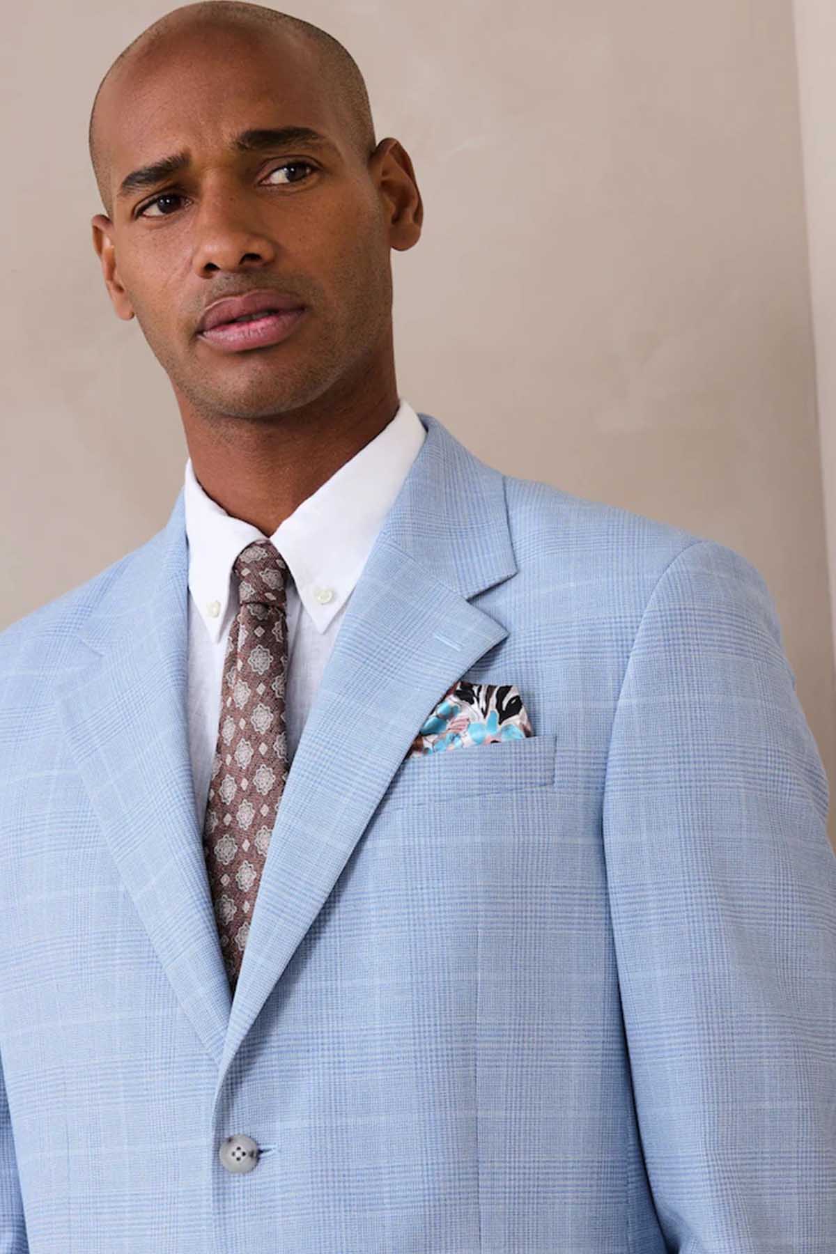 Light blue blazer lapel with pocket square and patterned necktie