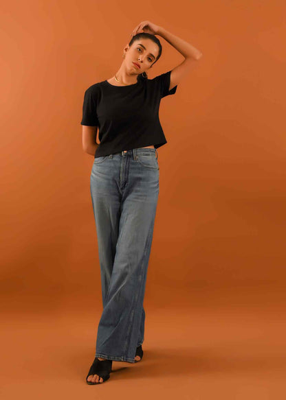 Black short-sleeve cropped T-shirt with light-wash wide-leg jeans, full body