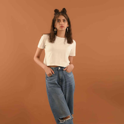 White short-sleeve crop top with round neck, paired with light blue ripped jeans