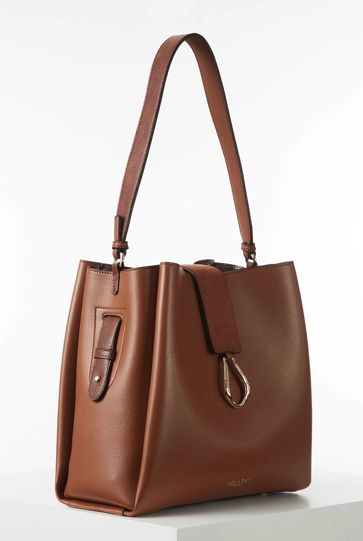 Brown leather tote bag with side straps, front clasp, and hanging key charm
