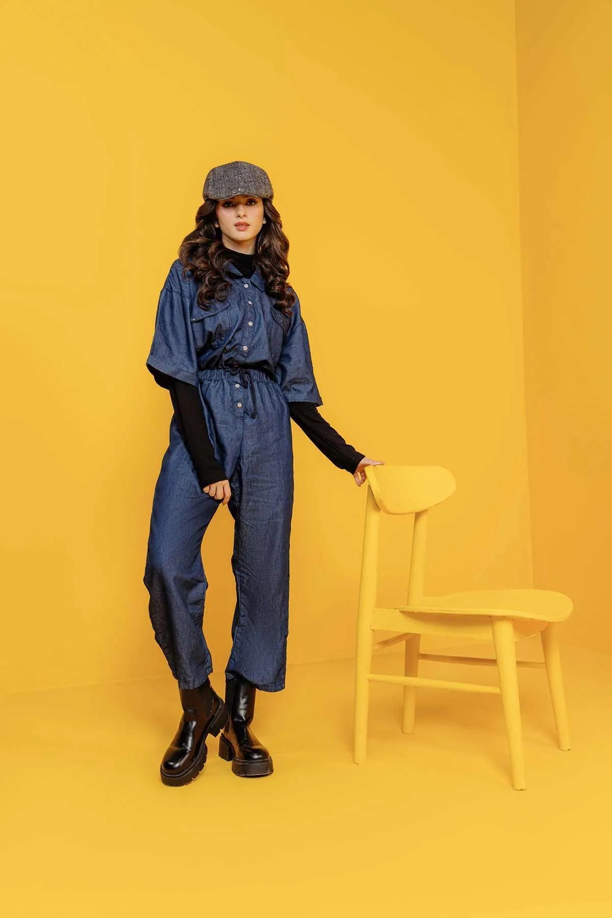 Mid-blue denim jumpsuit, button-front, long sleeves, belted waist, wide-leg pants