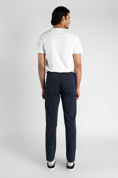 Blue jeans viewed from back, dark navy with side pockets and cuffed hem