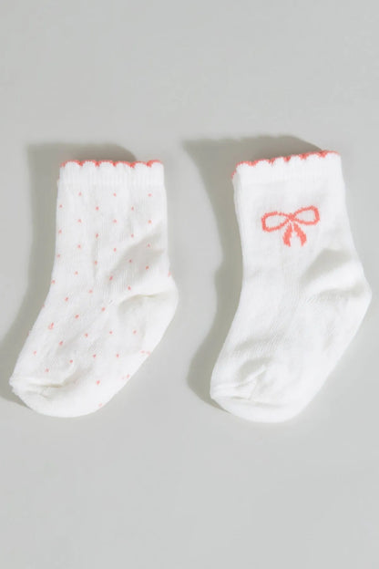 Cream ankle socks, one with bow and one with small dots, orange cuff trim
