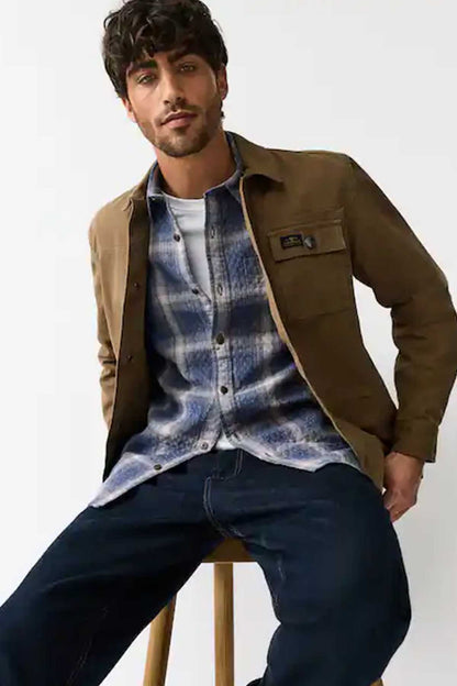 Men’s blue plaid button-up shirt worn under a brown jacket, button front visible