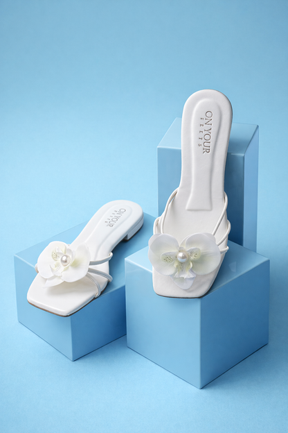 White slip-on mules with white floral embellishments and padded footbed