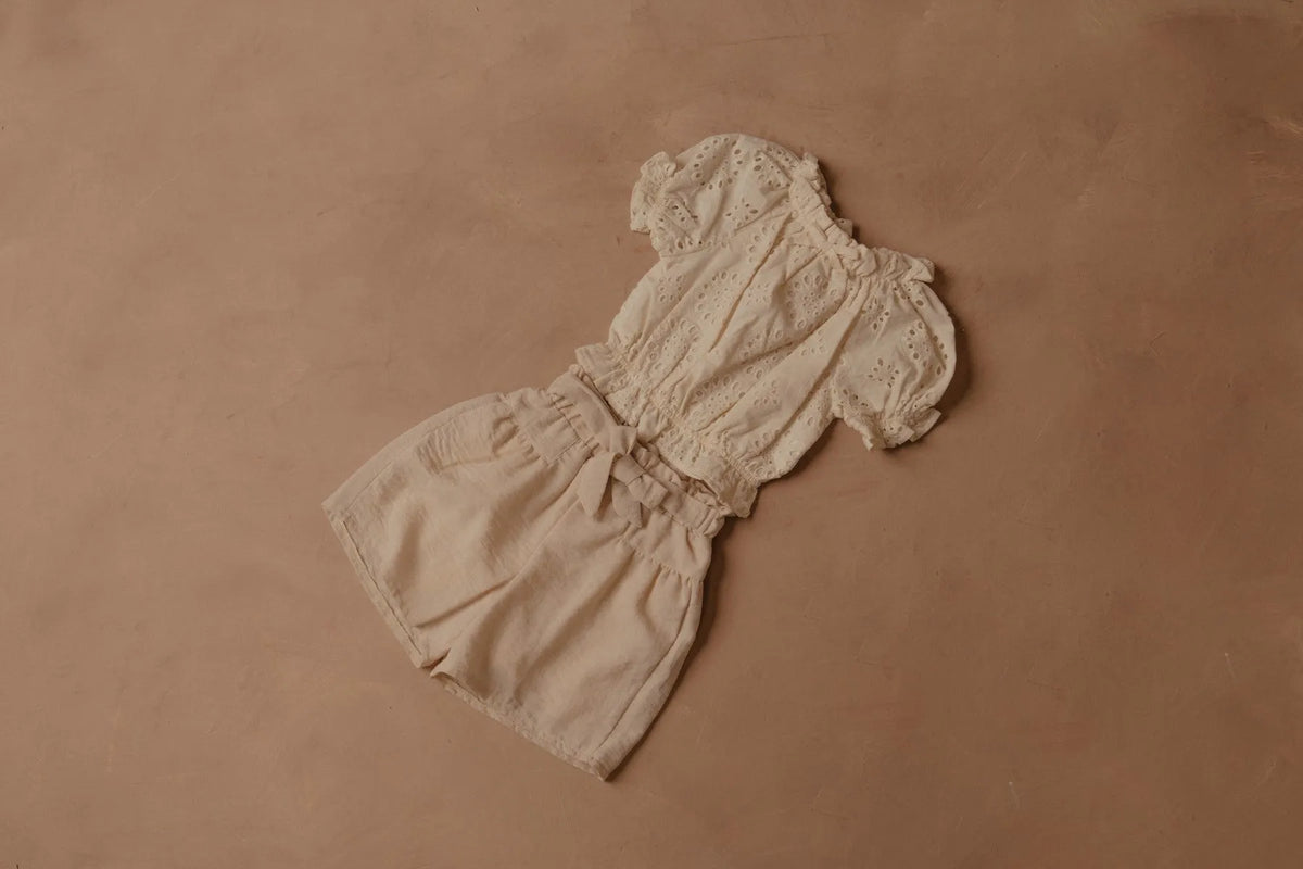 Cream shorts with elastic waist and bow detail at the front