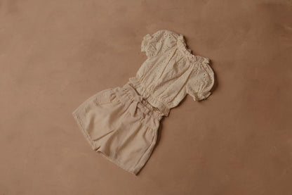 Cream shorts with elastic waist and bow detail at the front