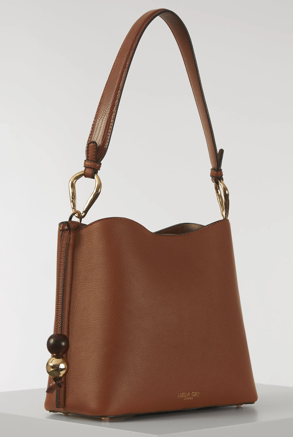 Brown leather bucket-style shoulder bag with single top handle and gold hardware