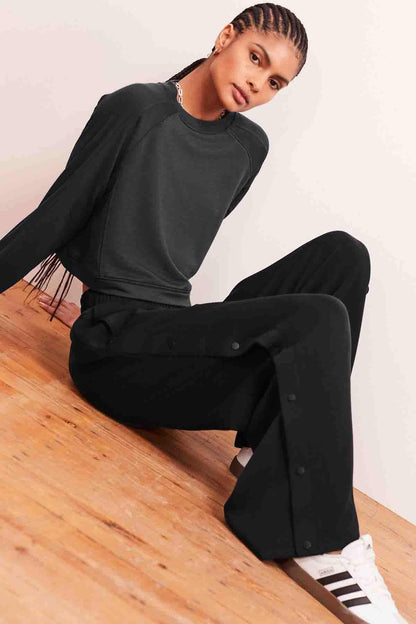 Charcoal grey wide-leg trousers with relaxed fit and side buttons