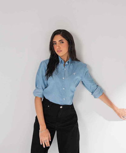 Fitted light blue button-up shirt with long sleeves and black jeans