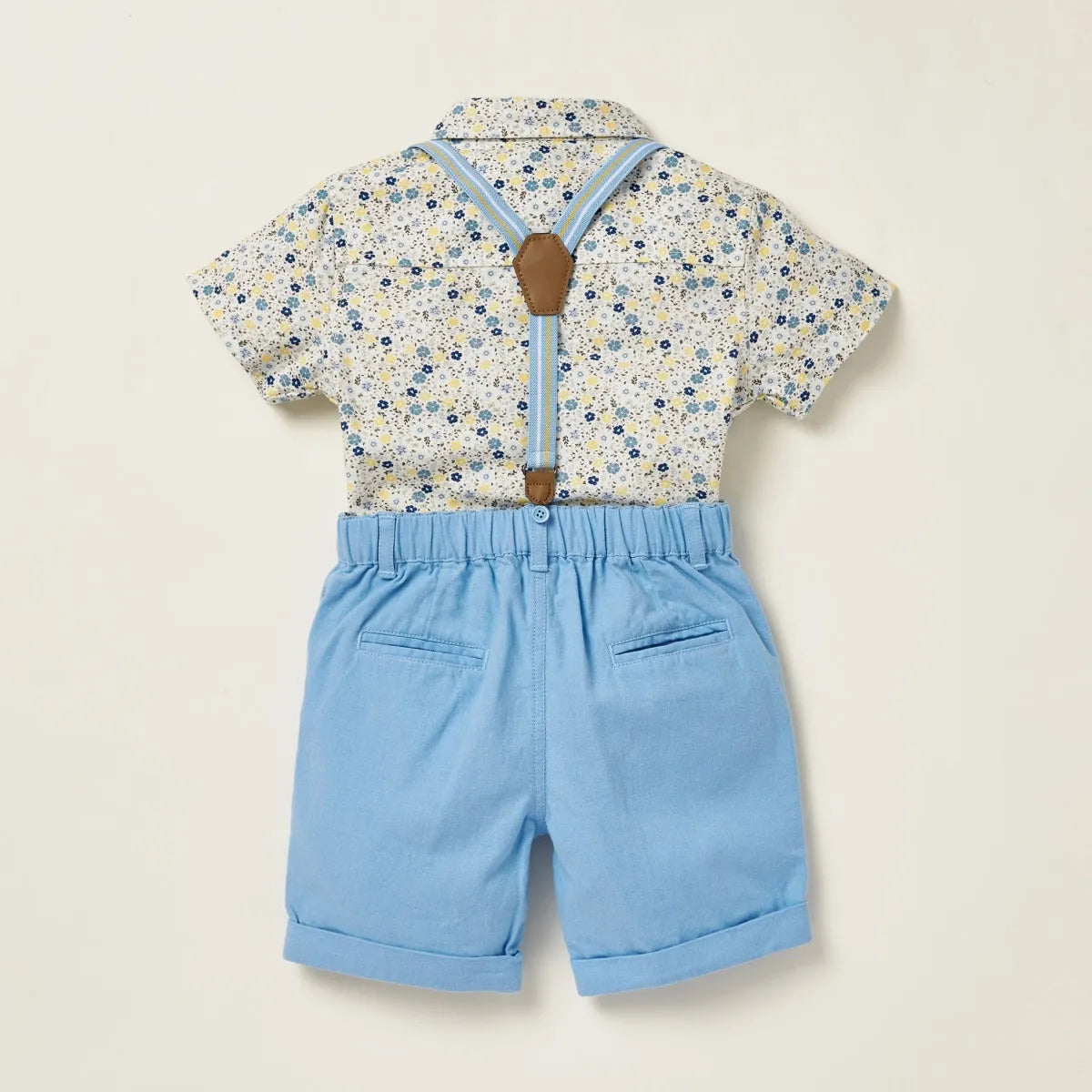 Baby patterned short-sleeve shirt and light blue shorts with suspenders, back view