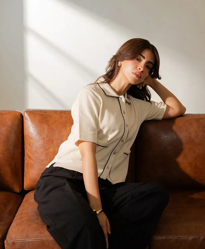 Ivory short-sleeve button-up top with stand collar and contrast piping detail.