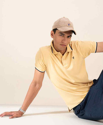 Yellow fitted polo shirt with dark-trim collar, short sleeves, and small chest logo