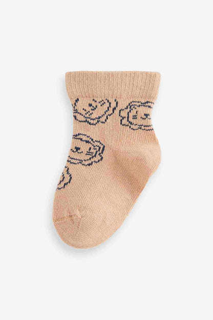 Light tan baby sock with navy swirl knit pattern