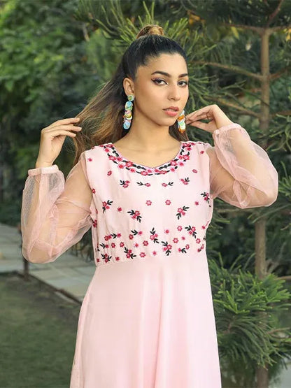 Pink floral-panel dress with sheer sleeves and long skirt.