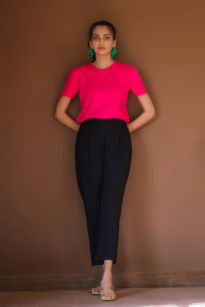 Womenâ€™s fuchsia short-sleeve blouse with dark navy fitted pants, front view