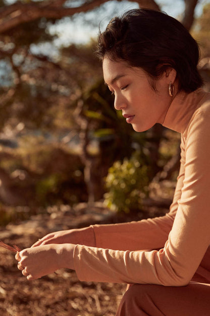 Beige long-sleeve turtleneck top, side view