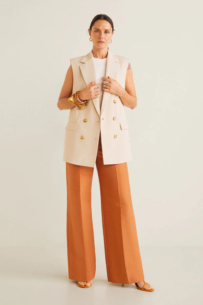 Off-white sleeveless blazer vest over white top with orange wide-leg trousers