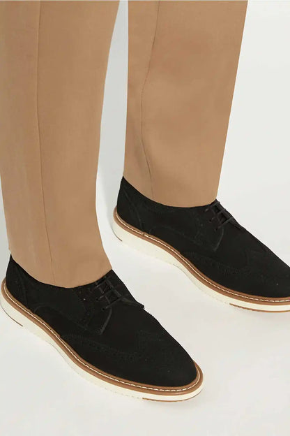 Dune London black lace-up shoe on foot, tan outsole trim