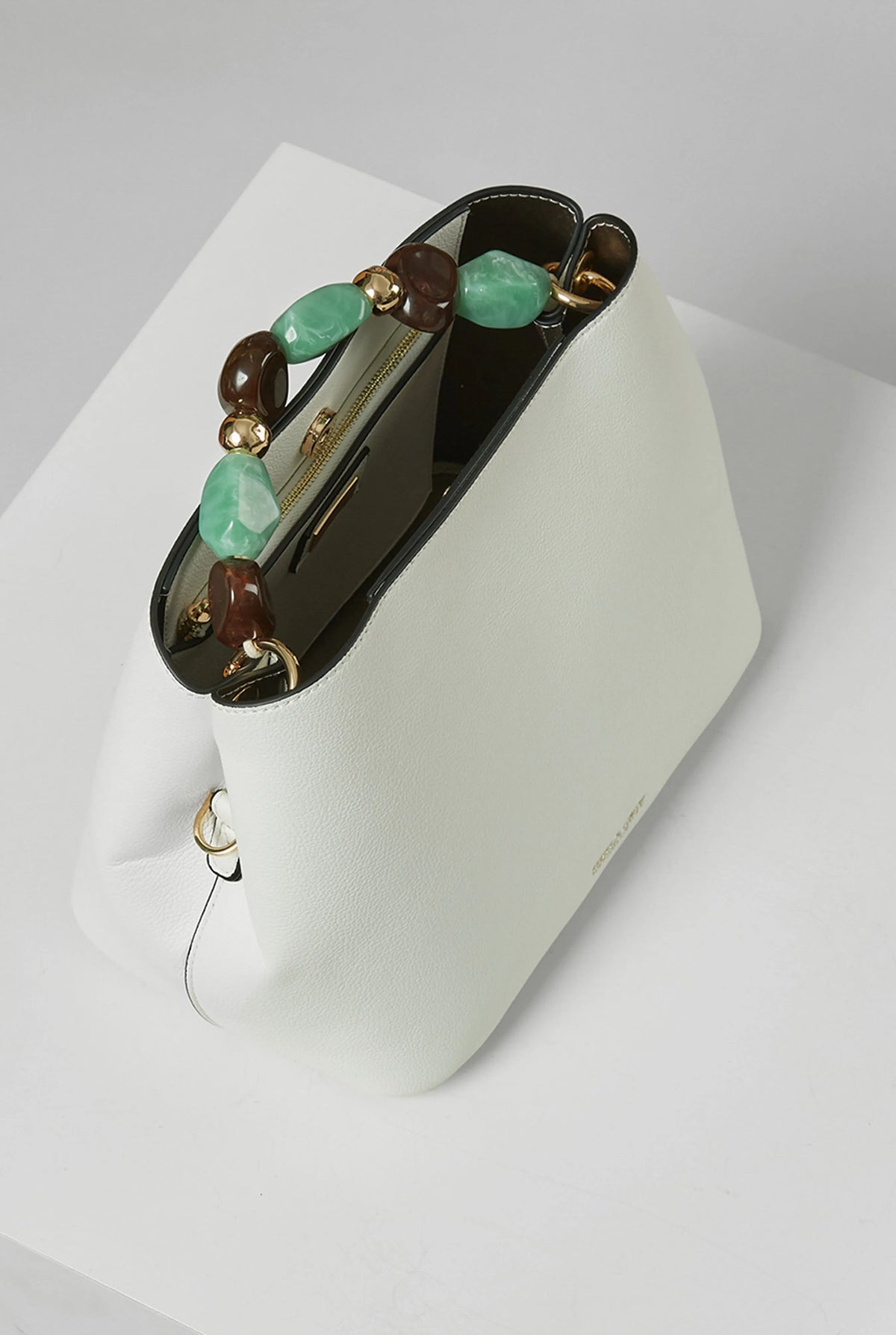 White bucket handbag with beaded handle, open top, gold-tone hardware detail