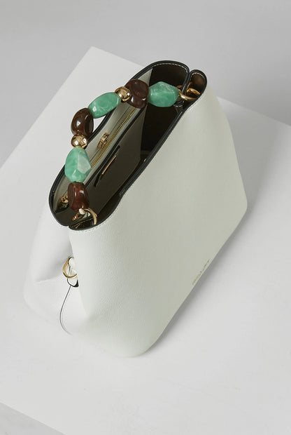 White bucket handbag with beaded handle, open top, gold-tone hardware detail