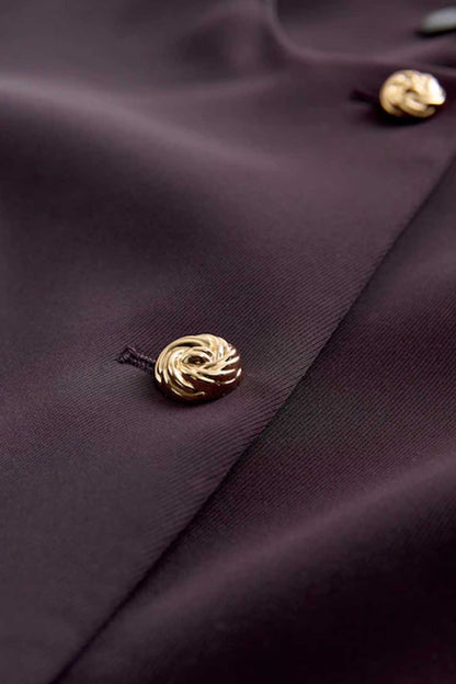 Gold button detail on dark purple blazer with smooth lapel edge