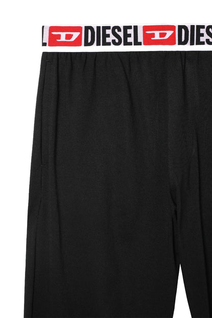 Black Diesel pants close-up: elastic waistband with repeated DIESEL logo
