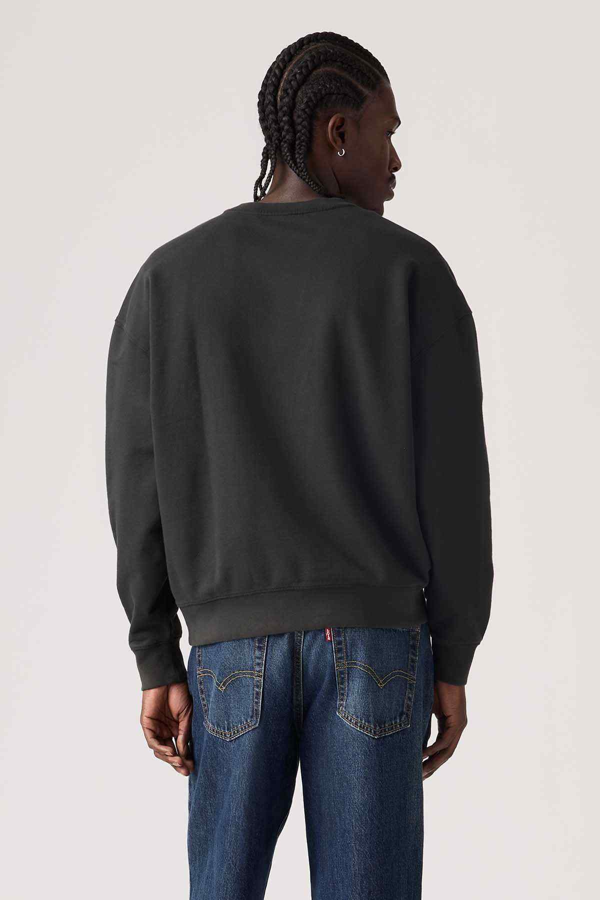 Back view of black crewneck sweatshirt with ribbed cuffs, relaxed fit