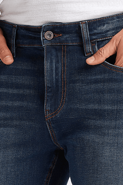Men's dark blue jeans close-up: belt loops, buttoned waistband, stitched pockets