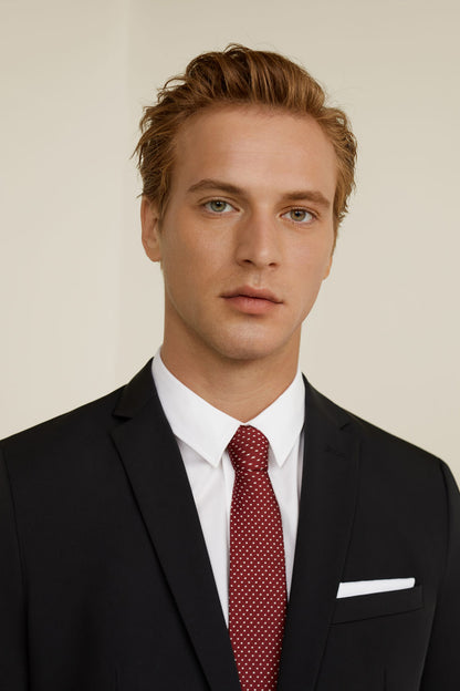 Men’s black suit jacket with white shirt, red patterned tie, and white pocket square