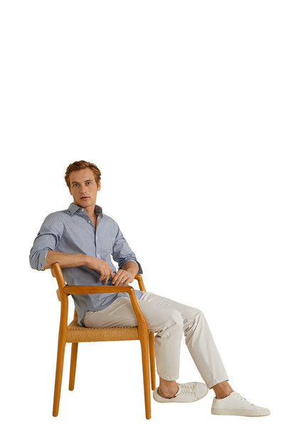 Men's blue button-up shirt worn with white pants, long sleeves, button front