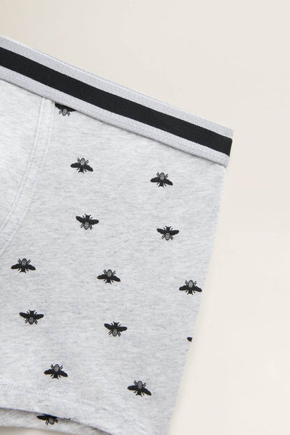 Grey boxer briefs fabric close-up with dark waistband and black spider print